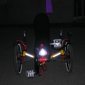 Trike von vorne, die 3M-Reflex-Folie am vorderen Träger ist ein Sicherheitsplus; man sieht die neue Kettenradabdeckung von HP ("Rammschutz" vulgo "Fußgängerfräse"); die Kombi-Pedale sind von Shimano PD-M324 (MountainBIKE 07/08 Urteil: Sehr Gut! Universalp