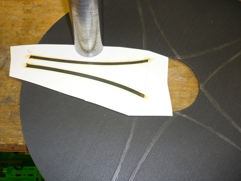 Radkappe-4. 
Mittels einer Schablone, bei mir 0,5 mm Kunststoff, wird die Kontur mittels orangem dünnen wasserfestem Faserschreiber auf dem Zuschnitt angezeichnet. Anschließend die Klebestellen für das Deco mit Pattex als Haftgrund bestrichen.